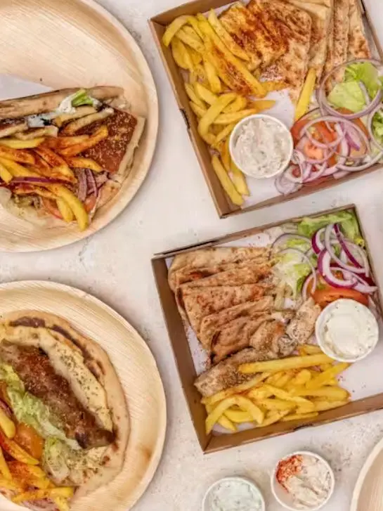 Four dishes of souvlaki and chips