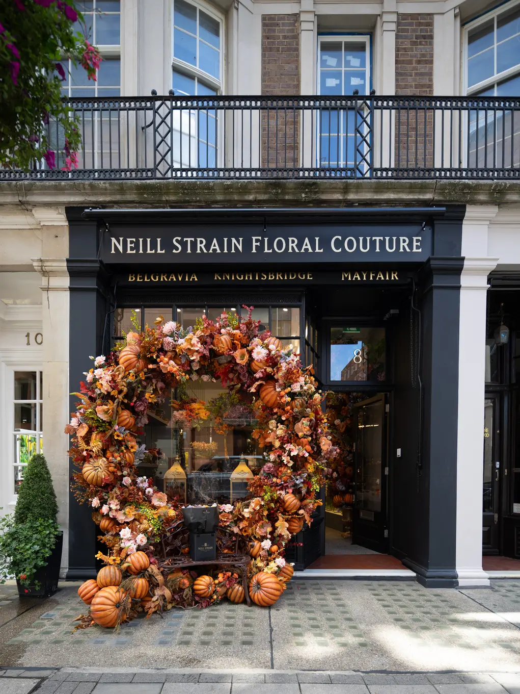 The shopfront of Neill Strain with an archway of pumpkins and autumn foliage