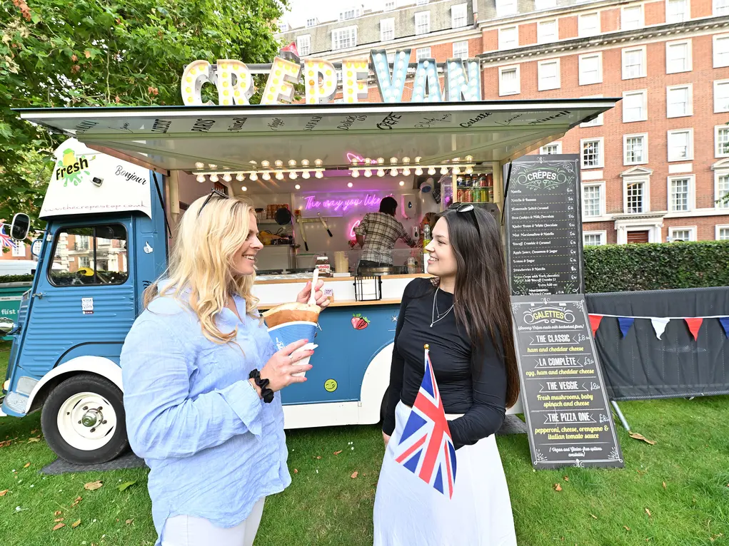 Two women standing in front of a crepe van